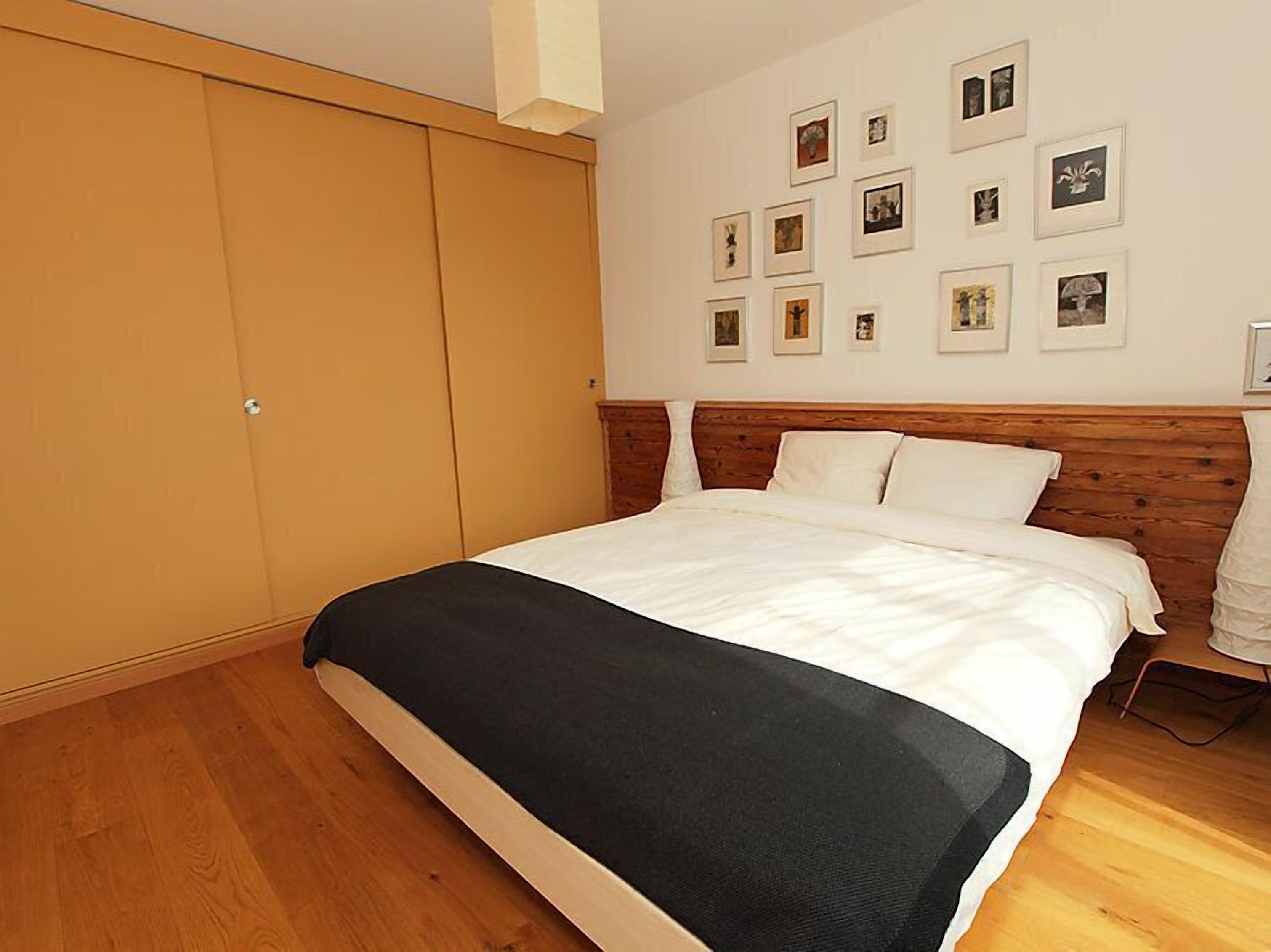 Een slaapkamer met een groot bed, een houten hoofdbord en een inloopkast.