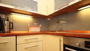 A compact kitchen with a microwave, a coffee maker, and a basket on the counter. - Apartment Walter by Interhome (Bad Hofgastein)