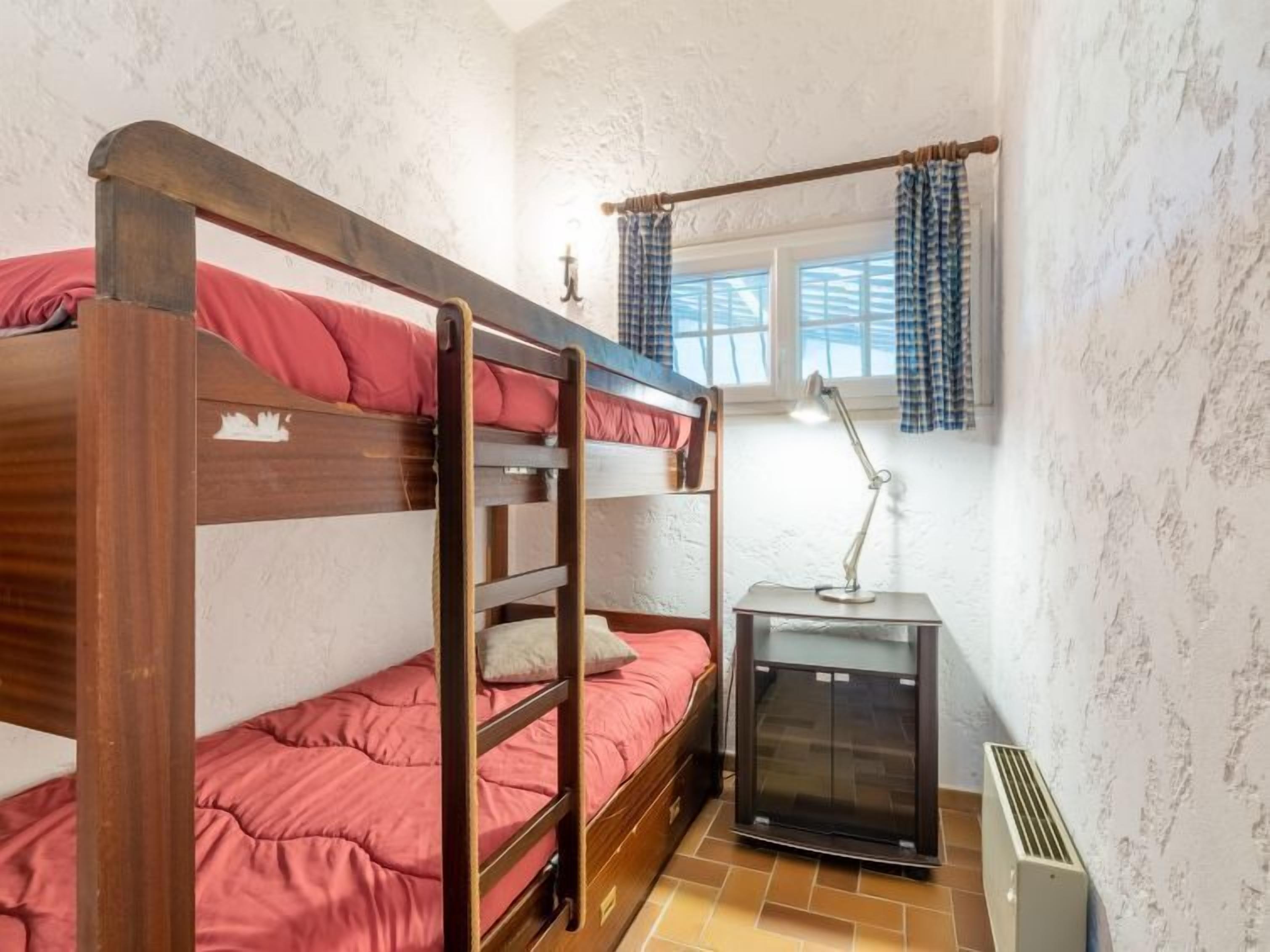 A bunk bed room with a heater and a desk lamp.