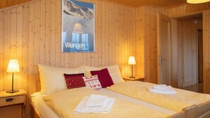 Una cama doble con cabecera de madera, dos mesitas de noche con lámparas y un cartel en la pared.