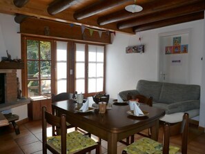A cozy dining area with a wooden table, chairs, and a fireplace. - Rustico L'Hibou by Interhome (Acquarossa)