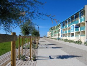 Un hôtel situé en bord de mer, doté de nombreux balcons, d’une promenade en bois et offrant une vue dégagée sur l’océan.