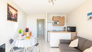 Un appartement moderne comprenant un coin repas, une cuisine et un salon.