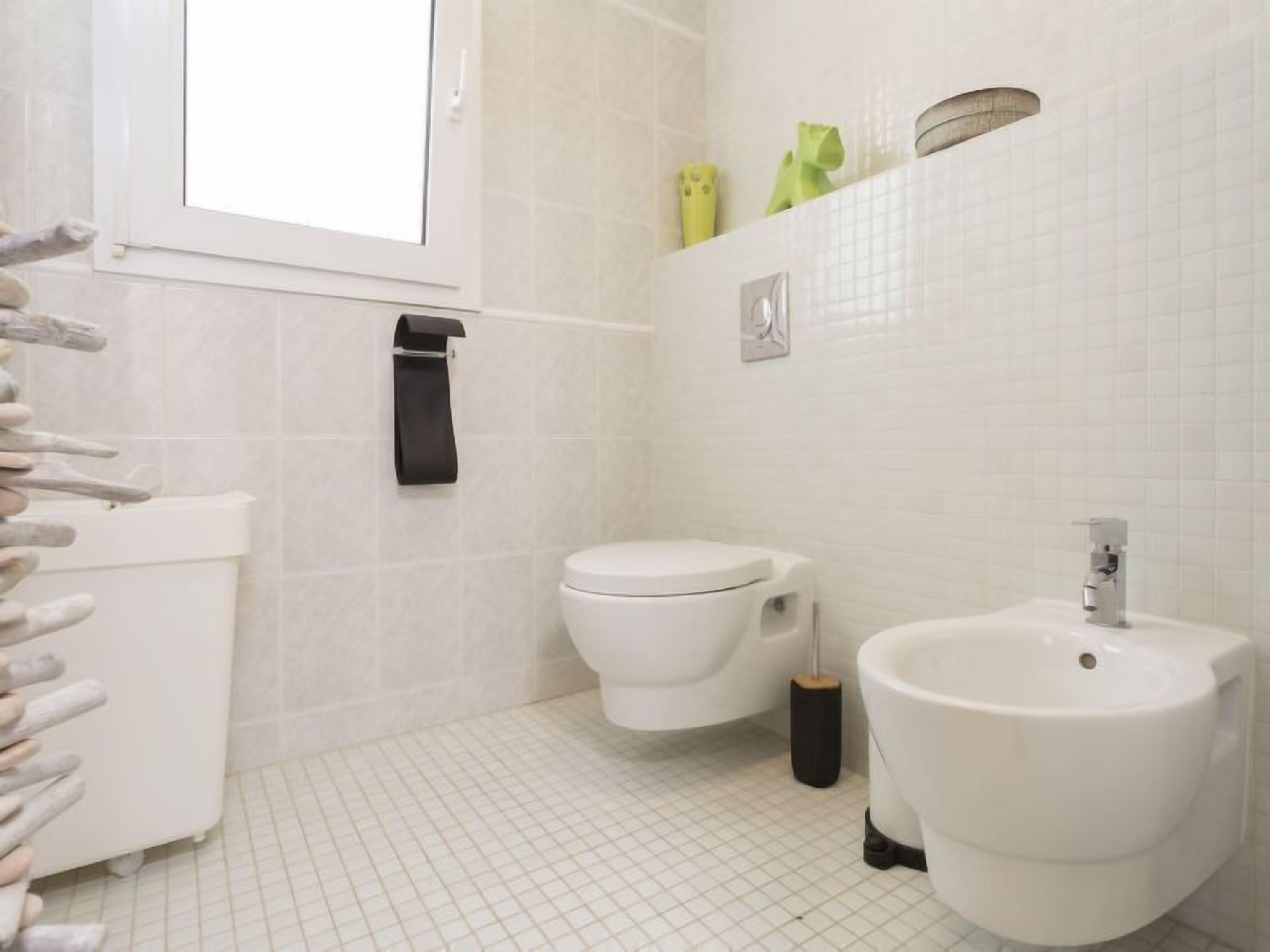 A bathroom with a toilet, bidet, and sink.
