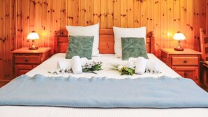 Una stanza con rivestimento in legno, un letto, due comodini e due lampade.