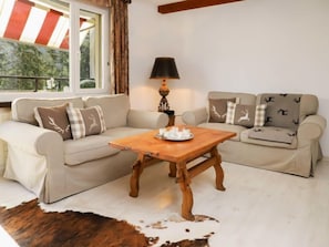 Ein gemütliches Wohnzimmer mit einer Couch, einem Holztisch und einer Lampe.