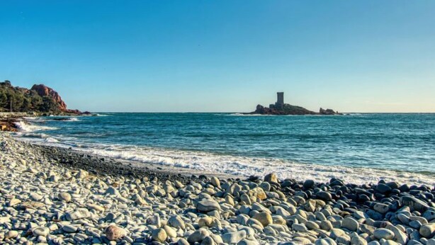 A rocky beach with waves crashing onto the shore and a distant rocky outcrop. - Boulouris Mimosa by Interhome (Saint-Raphaël)