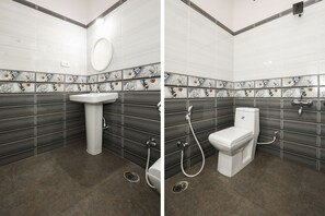A bathroom with a white sink, a toilet, and a shower. The walls are tiled with a floral pattern.