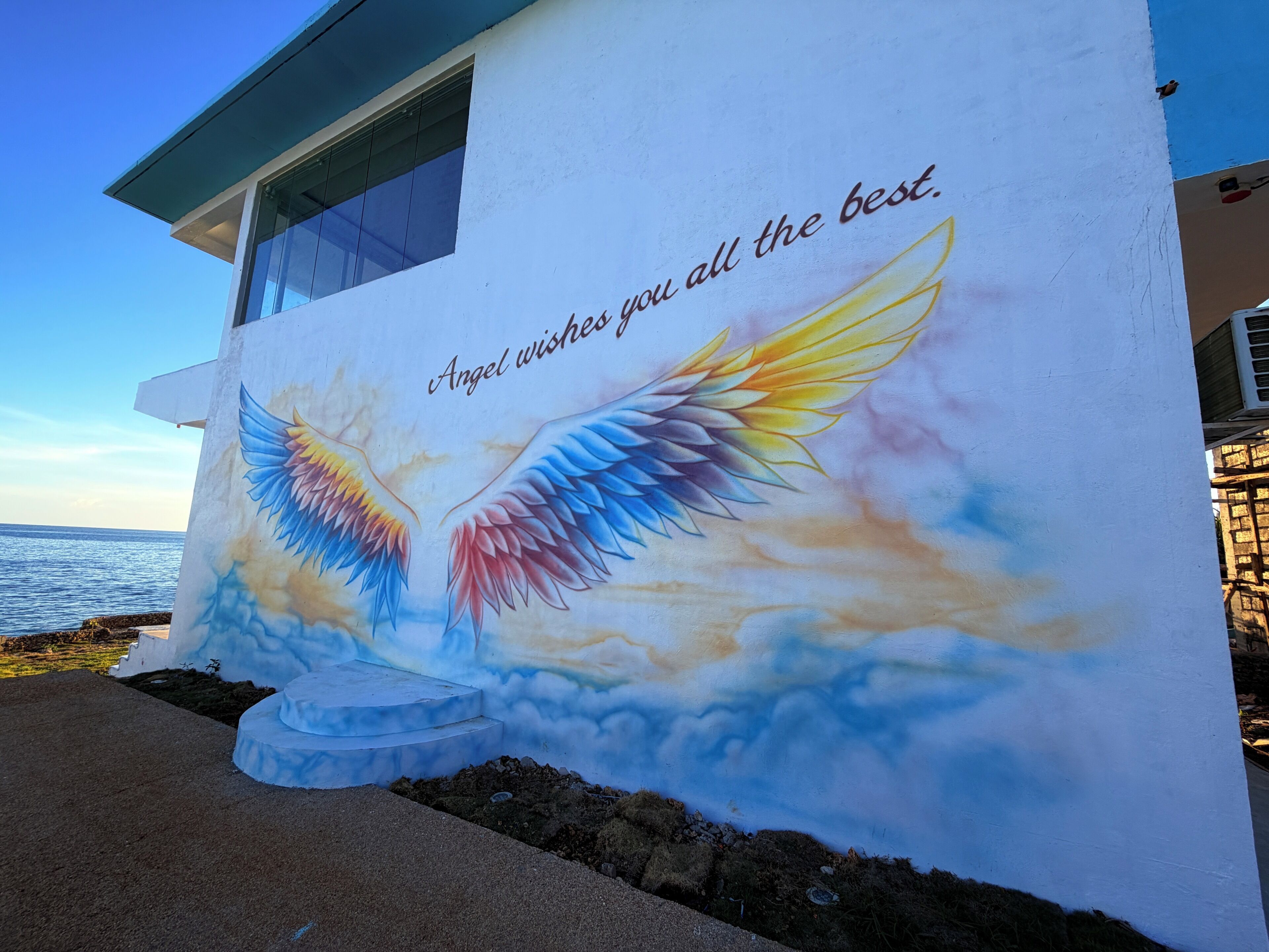 Un edificio con un mural de alas y un mensaje.