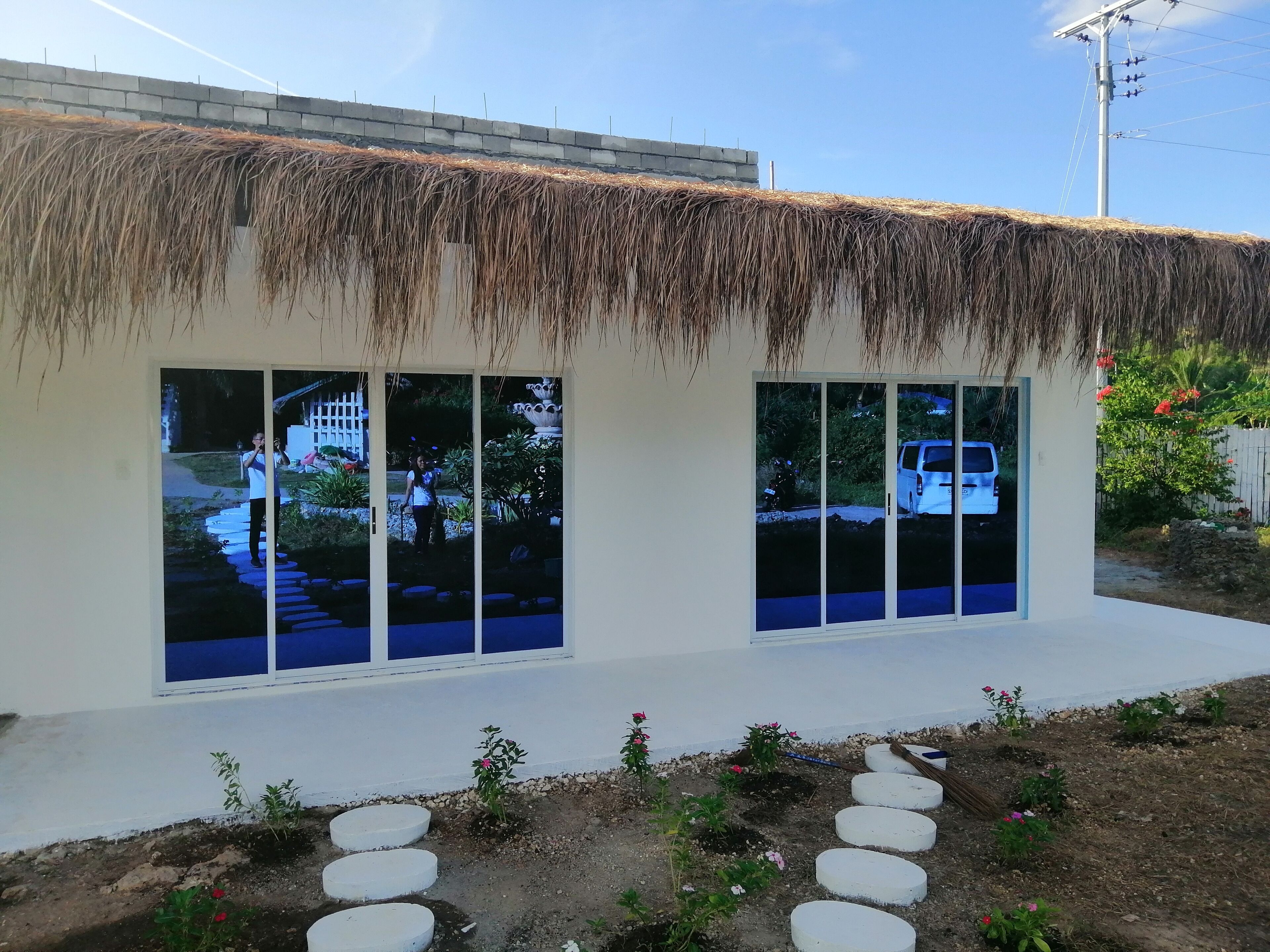 A building with a thatched roof and large windows.