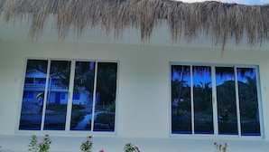 A building with a thatched roof and large windows.