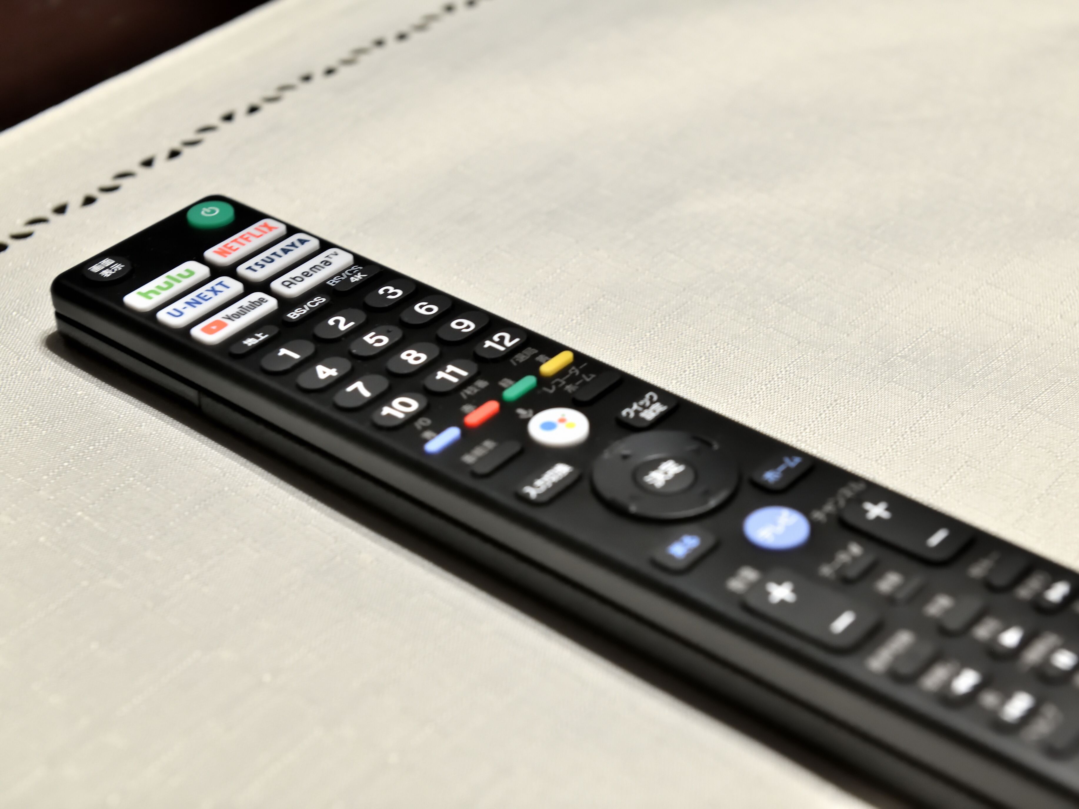 A black remote control with multiple buttons including Netflix, Hulu, and YouTube.