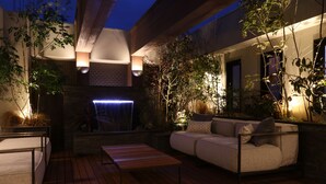 An outdoor patio with a wooden deck, a sofa, and a table. - Amistad Hotel Fukuoka (Fukuoka)
