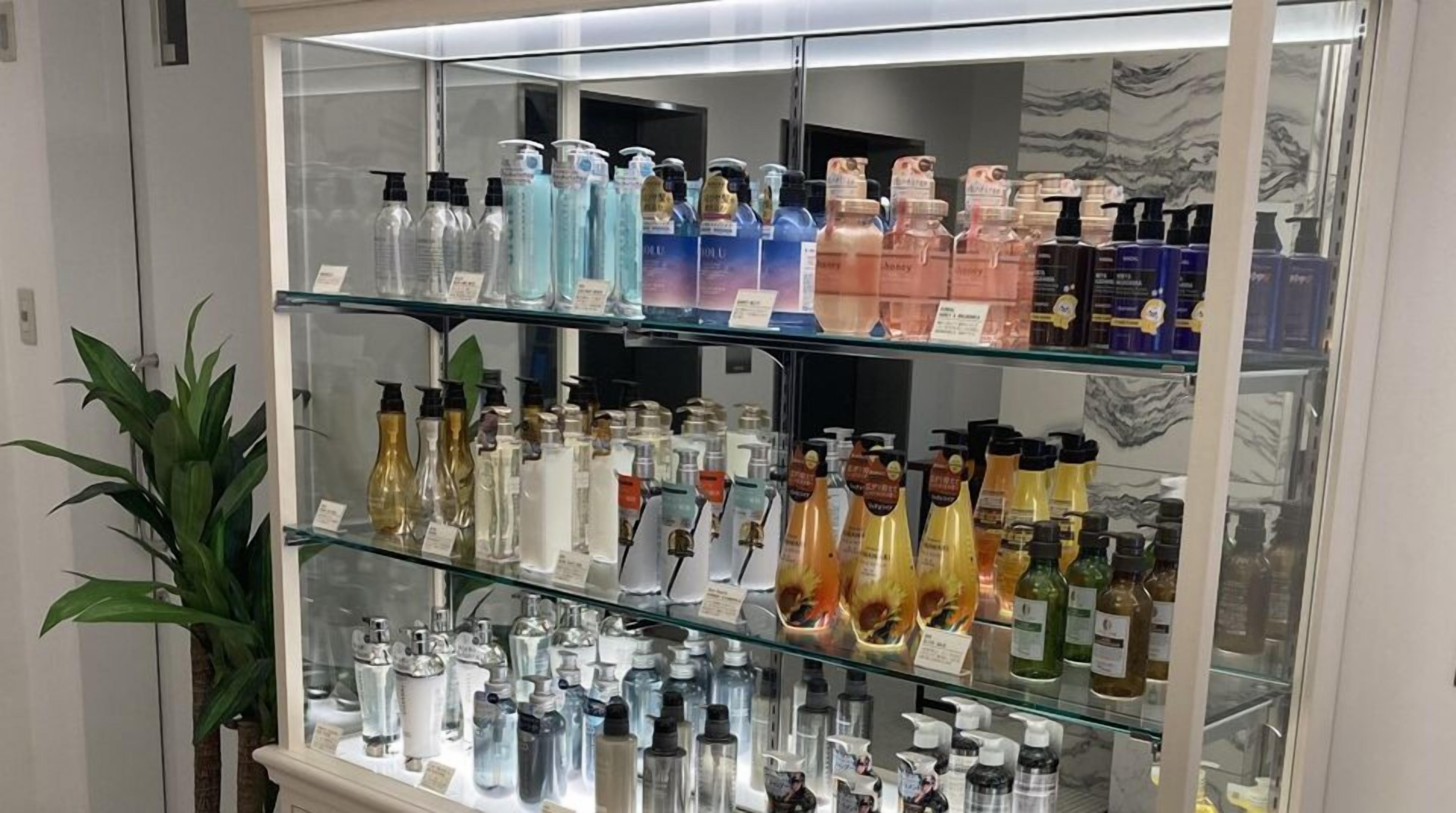 A glass display case with various bottles of personal care products.