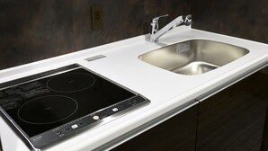 A modern kitchen with a built-in stovetop and a stainless steel sink. - Amistad Hotel Fukuoka (Fukuoka)