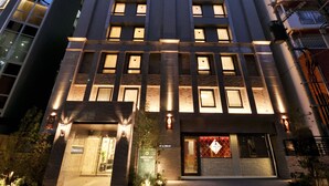 A modern hotel with a symmetrical facade, multiple windows, and a prominent entrance with a sign. - Amistad Hotel Fukuoka (Fukuoka)