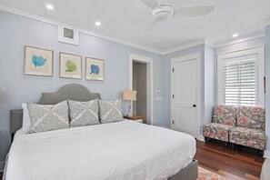 A bedroom with a bed, a nightstand, a chair, and framed artwork on the wall. - Huge at 2,360 SqFt, Golf Cart & 4 Bikes! 4 WaterColor Pools, Beach Club & Camp - Bess Place on Earth (Santa Rosa Beach)