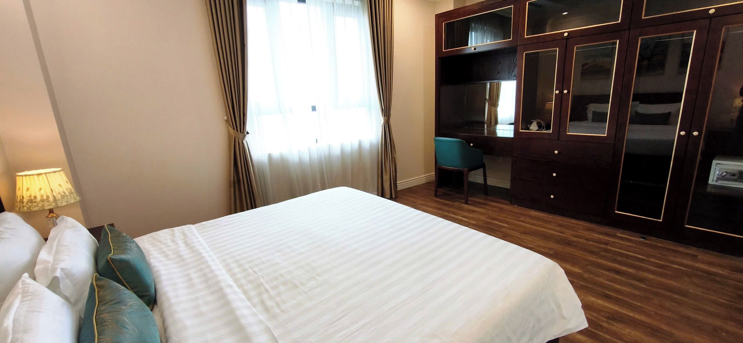 Une chambre d’hôtel avec un grand lit, un bureau et une armoire à plusieurs portes.