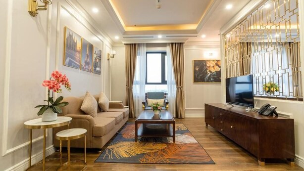 Una sala de estar moderna con un sofá, una mesa de centro, un televisor y elementos decorativos.