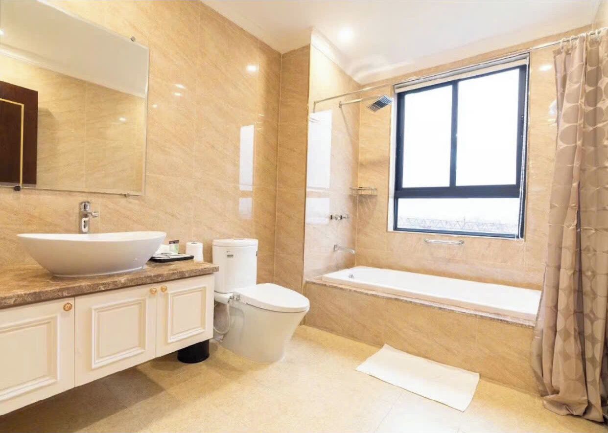 Een badkamer met een groot wastafel, toilet en bad.