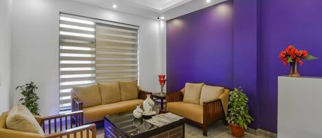 Deluxe Double Room | Living area | 32-inch LED TV with cable channels, TV, DVD player