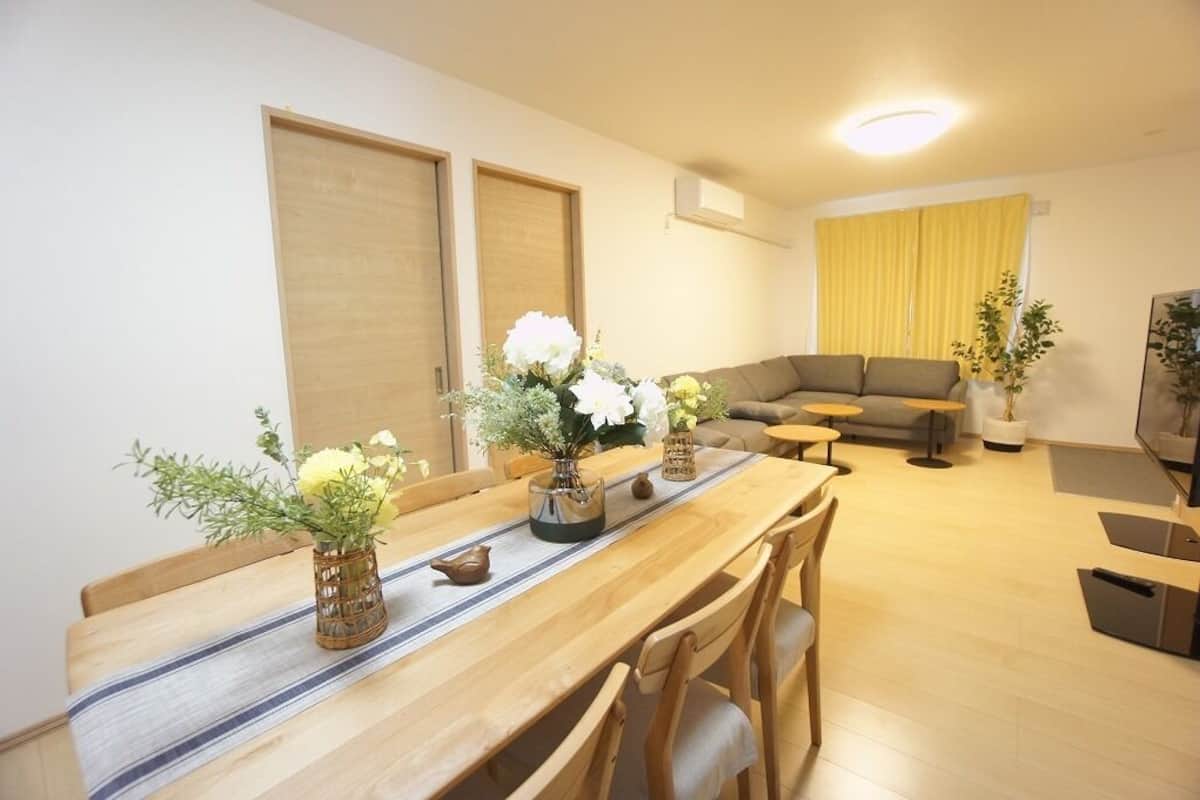 Ein modernes Wohnzimmer mit Holzesstisch, einer Couch und einem kleinen Couchtisch.