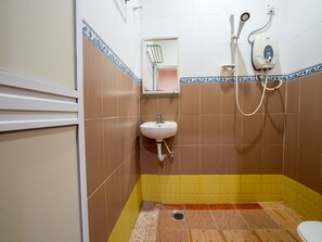 A bathroom with a sink, a mirror, and a shower.