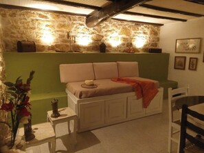A cozy room with a sofa, a small table with a lamp, and a decorative vase.