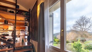 A staircase leading to a kitchen area with a view of a garden through a large window. - Urdaibai by Interhome (Urdaibai/Busturia)