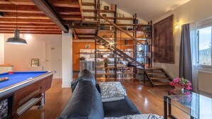 A modern living room with a pool table, a sofa, and a staircase leading to a kitchen area. - Urdaibai by Interhome (Urdaibai/Busturia)