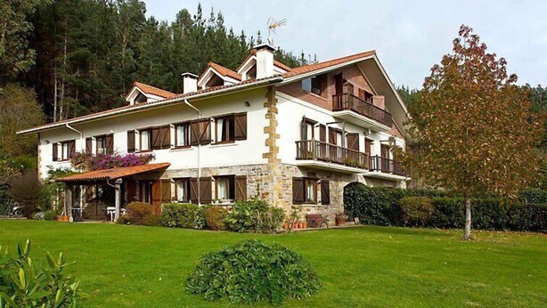 A two-story building with a stone facade, multiple balconies, and a well-maintained lawn. - Urdaibai by Interhome (Urdaibai/Busturia)