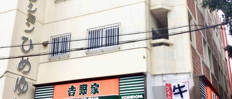 A building with multiple signs, including one for 'Yoshinoya' and another for a restaurant.