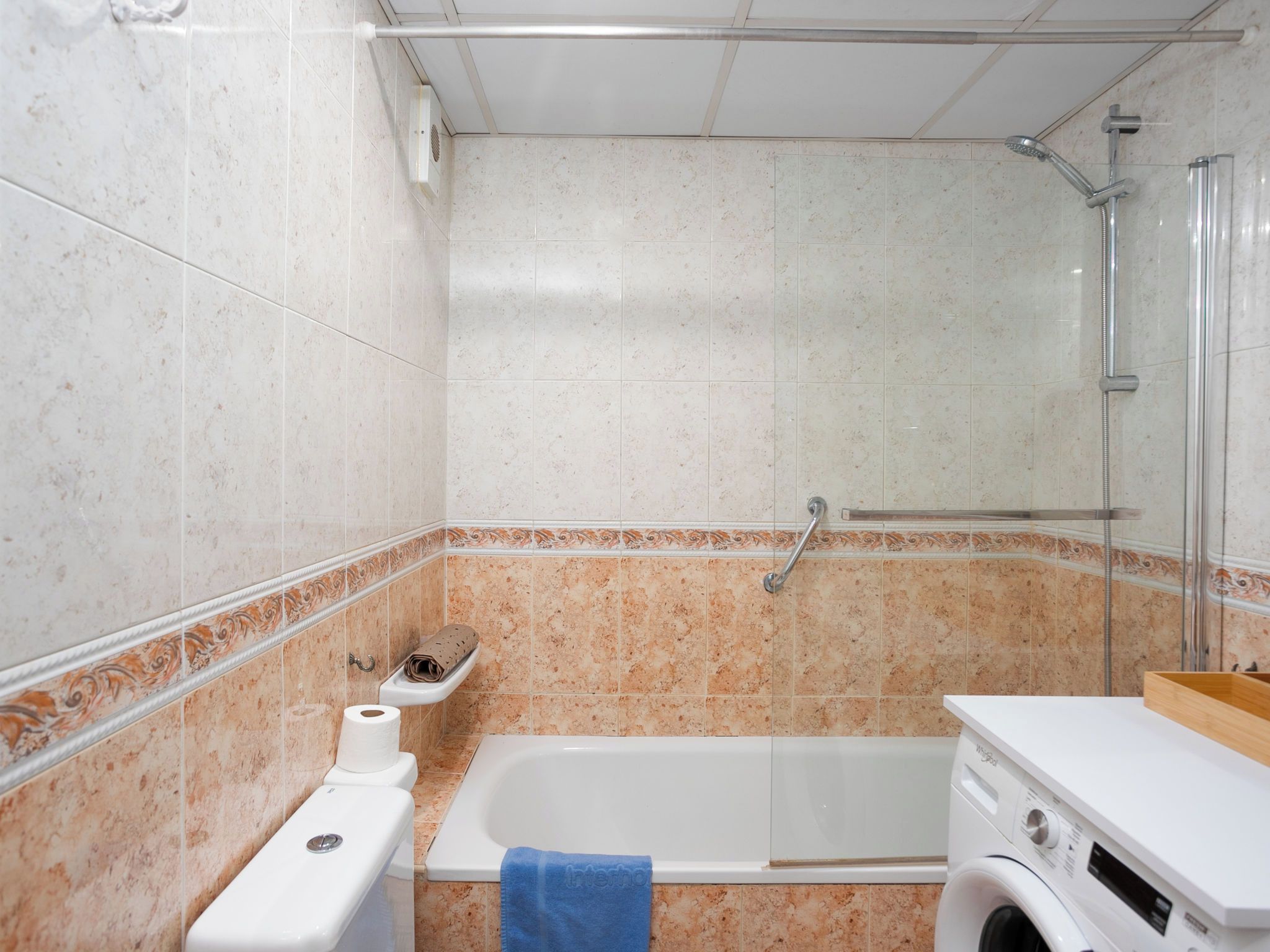 Een badkamer met een bad, toilet en douche.
