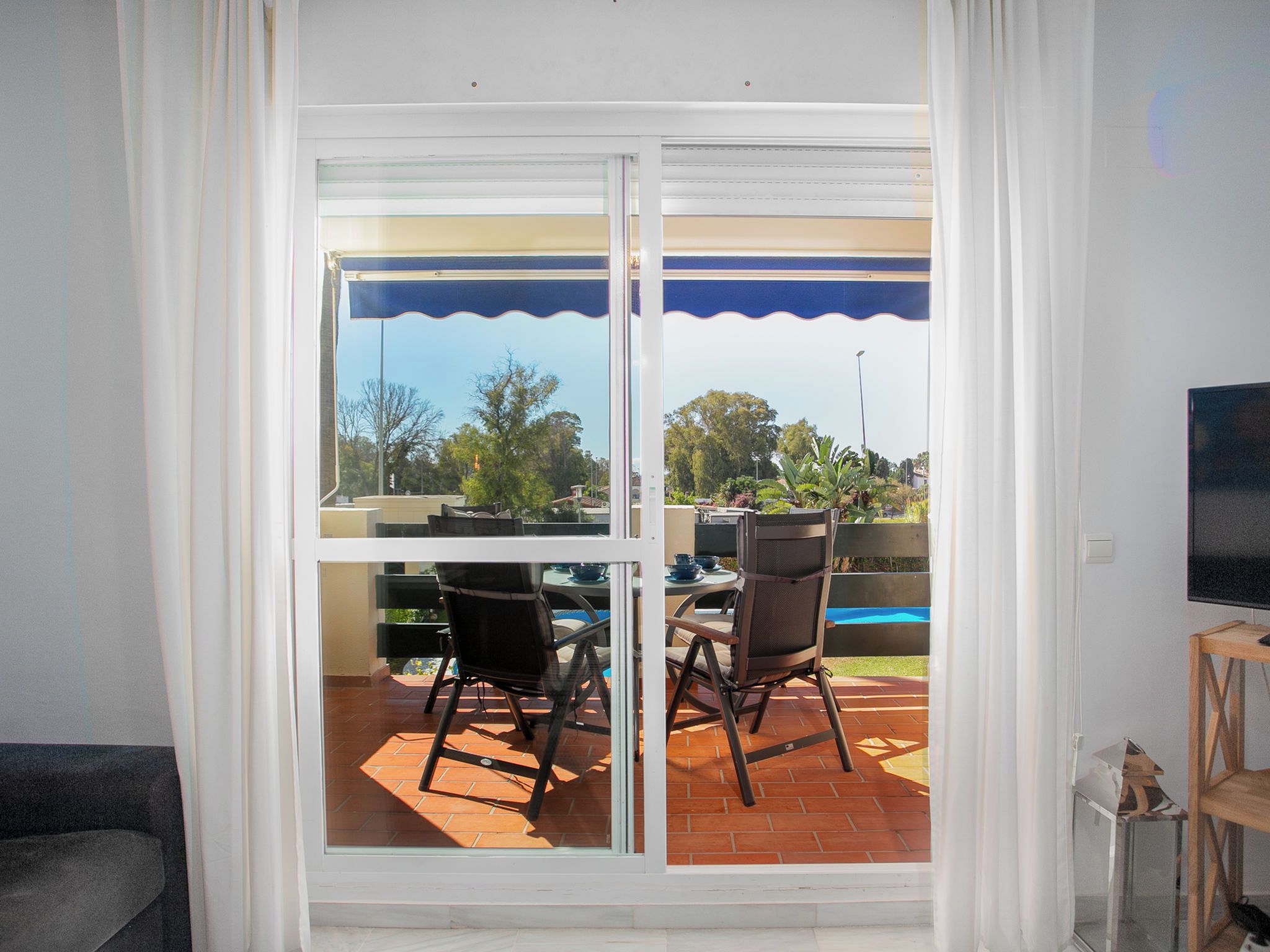 A room with a sliding glass door leading to an outdoor patio area with a table and chairs.