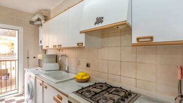 Een koelkast, een microgolfoven, een oven, kookgerei, borden en bestek