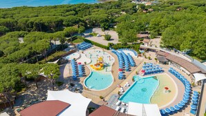 Ein Resort mit mehreren Schwimmbecken, einem Wasserpark und einem Strandbereich mit Sonnenschirmen.