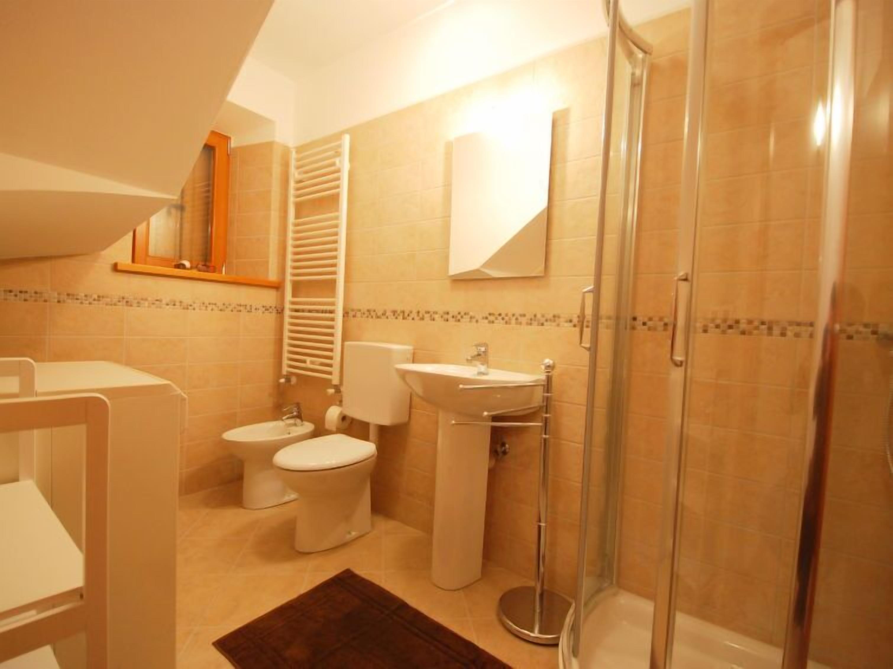 A bathroom with a shower, toilet, and sink.