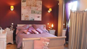 Un dormitorio con cama, mesitas de noche, lámpara y un adorno en la pared.
