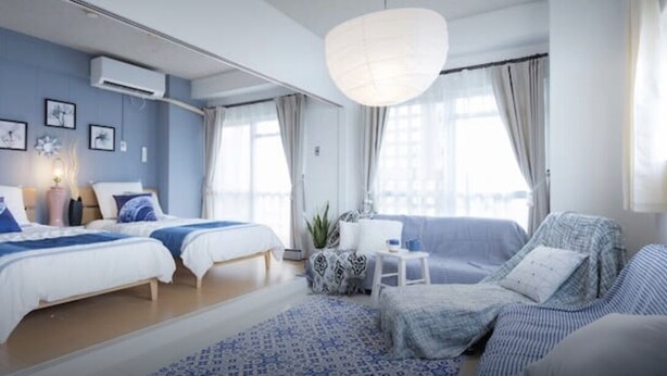 Une chambre moderne avec deux lits, un canapé et une petite table.
