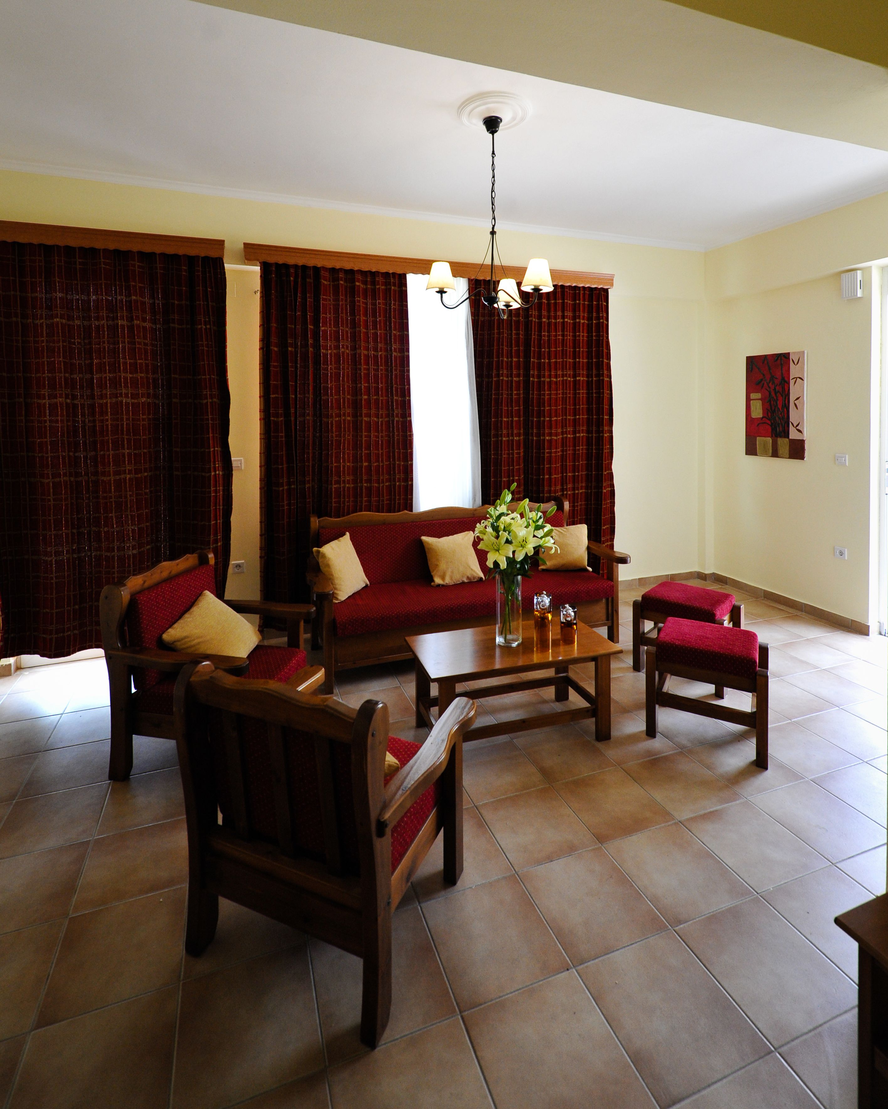 Een woonkamer met een bank, twee fauteuils, een salontafel en een kroonluchter.