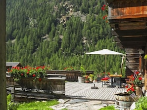 A wooden deck with outdoor seating, surrounded by a mountainous landscape. - Beim Holzschnitzer by Interhome (Sölden)