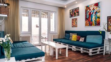 Una sala moderna con un sofá, una mesa de centro y vistas amplias a través de puertas de cristal.