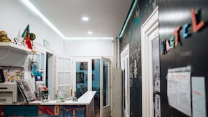 Una cocina con una isla colorida, un refrigerador y una puerta con una pizarra.