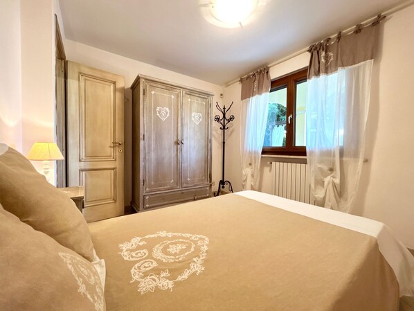 Une chambre à coucher avec un lit, une armoire et un porte-manteau.