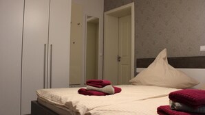 A bedroom with a bed, two wardrobes, and a mirror. - Altstadt Villa Wohnung 2 Hooge (Borkum)
