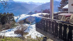 A balcony with a view of snow-covered mountains and a clear sky. - Chalet Aglaia by Interhome (Crans-Montana)