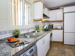 Een koelkast, een microgolfoven, een oven, kookgerei, borden en bestek