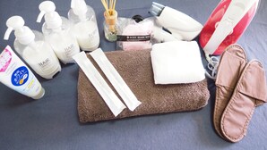 A variety of toiletries and personal care items, including bottles of shampoo, body wash, and hair conditioner, arranged on a textured surface. - Holiday Homes TSUBOYA 4th (Naha)