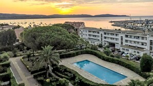 A hotel with a swimming pool, surrounded by greenery and overlooking a marina with boats. - Le Grand Pavois by Interhome (Cavalaire)