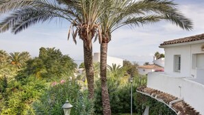 A white building with a curved staircase and a palm tree in the foreground. - Oasis Beach by Interhome (Dénia)
